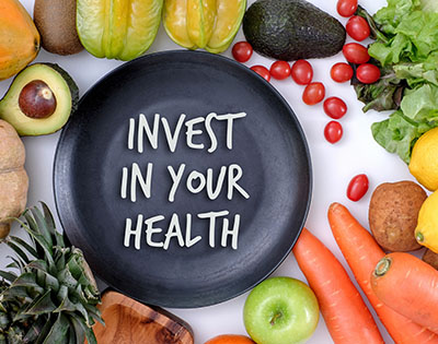 Eating Healthy - a plate with healthy fruit all around and the plate says Invest In Your Health